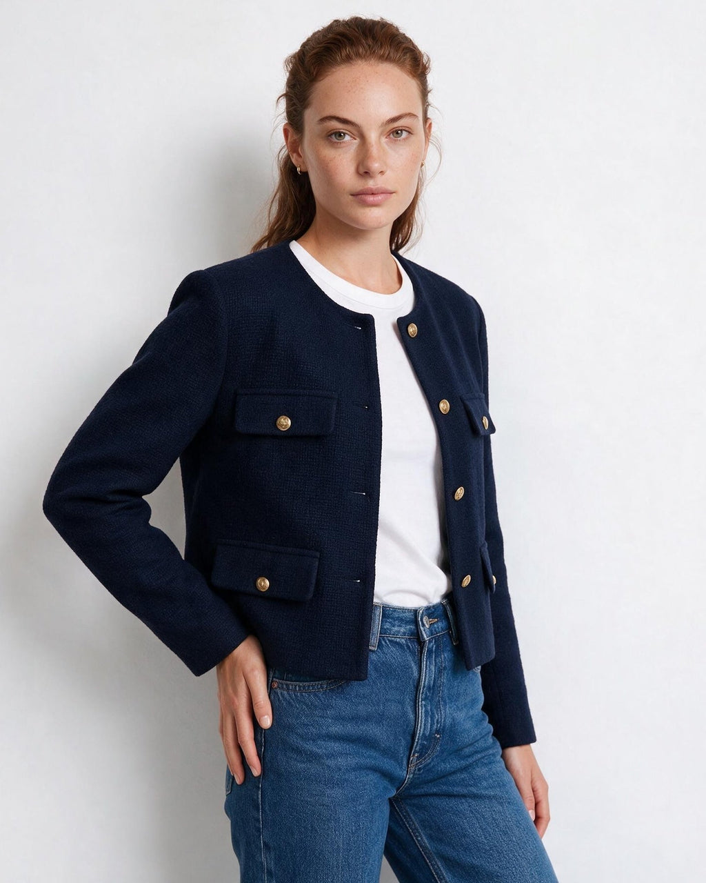 Women’s navy cropped collarless jacket, button front with four flap pockets and gold buttons.