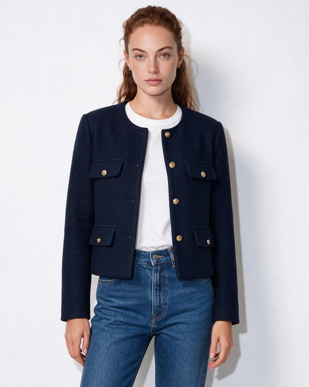 Dark navy cropped collarless jacket with four flap pockets and gold button trim