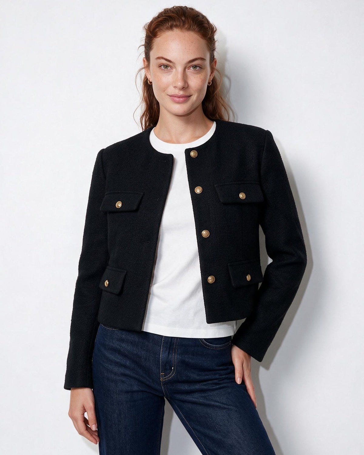 Black cropped collarless jacket with four flap pockets and gold button closures