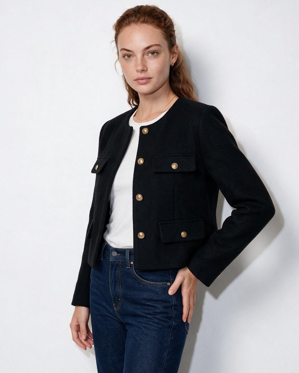 Cropped collarless jacket in black with gold buttons and four flap pockets