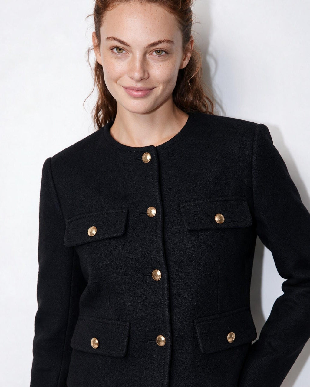 Cropped collarless jacket in black with front gold buttons and four flap pockets