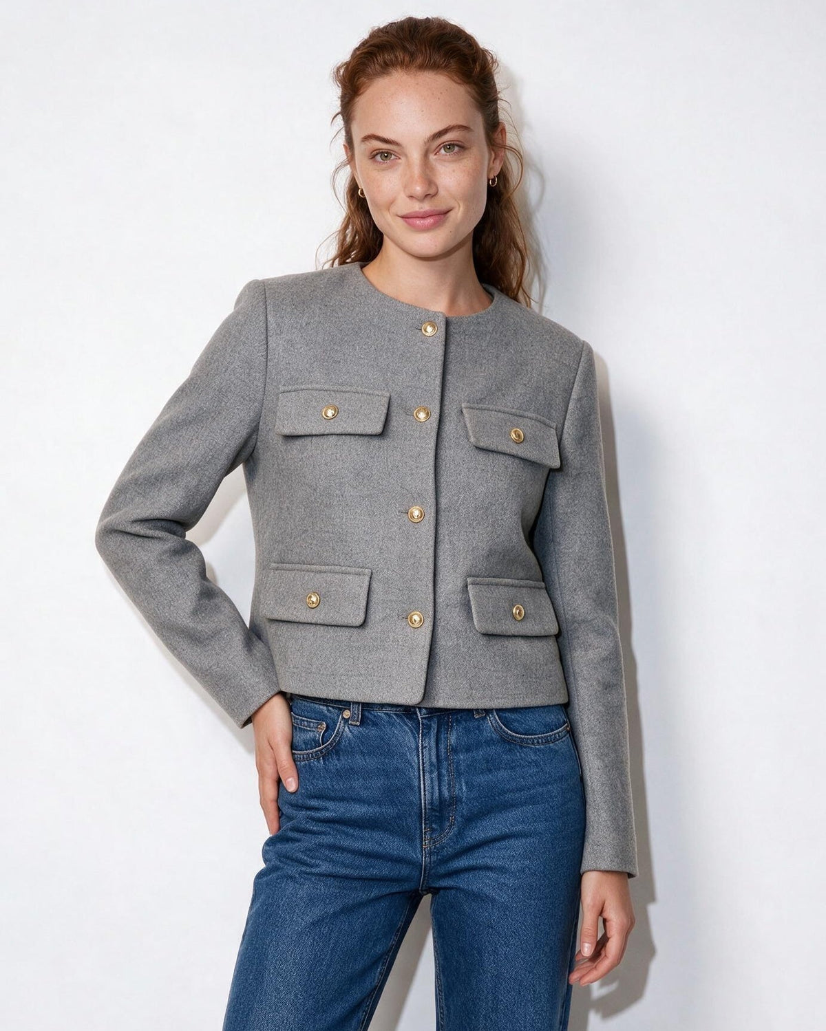 Grey cropped collarless jacket with four flap pockets and gold buttons