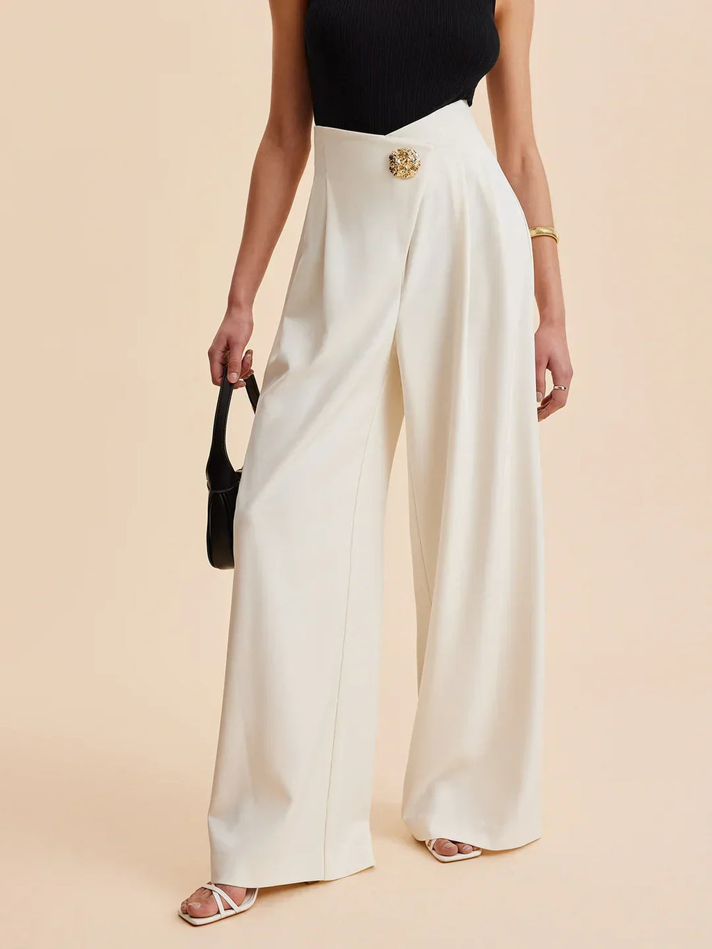 Cream wide-leg tailored pants with front pleat and gold waistband button