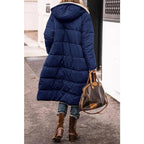 Dark blue longline puffer jacket with hood and tan sherpa lining on the inside