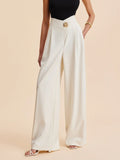 Cream wide-leg tailored pants with tailored front crease and gold waistband button