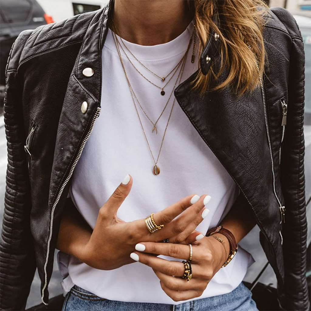 Black leather moto jacket with asymmetrical front zip, side zippers, and snap shoulder tabs