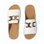 Women’s white wedge comfort sandals with metallic square buckle straps and open toe.