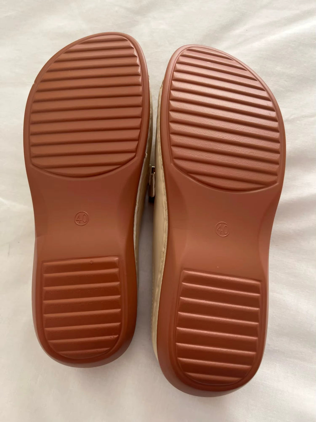 Women’s wedge comfort sandal outsole view with textured tread on brown rubber.