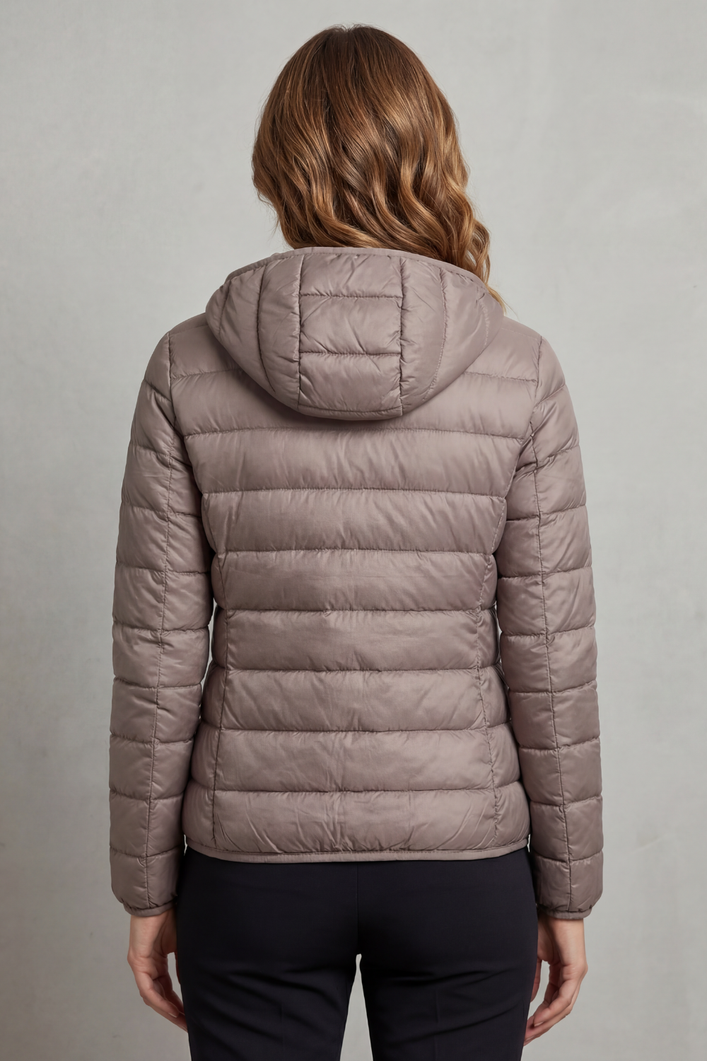 Women’s hooded puffer jacket in light grey, back view with hood and quilted panels.