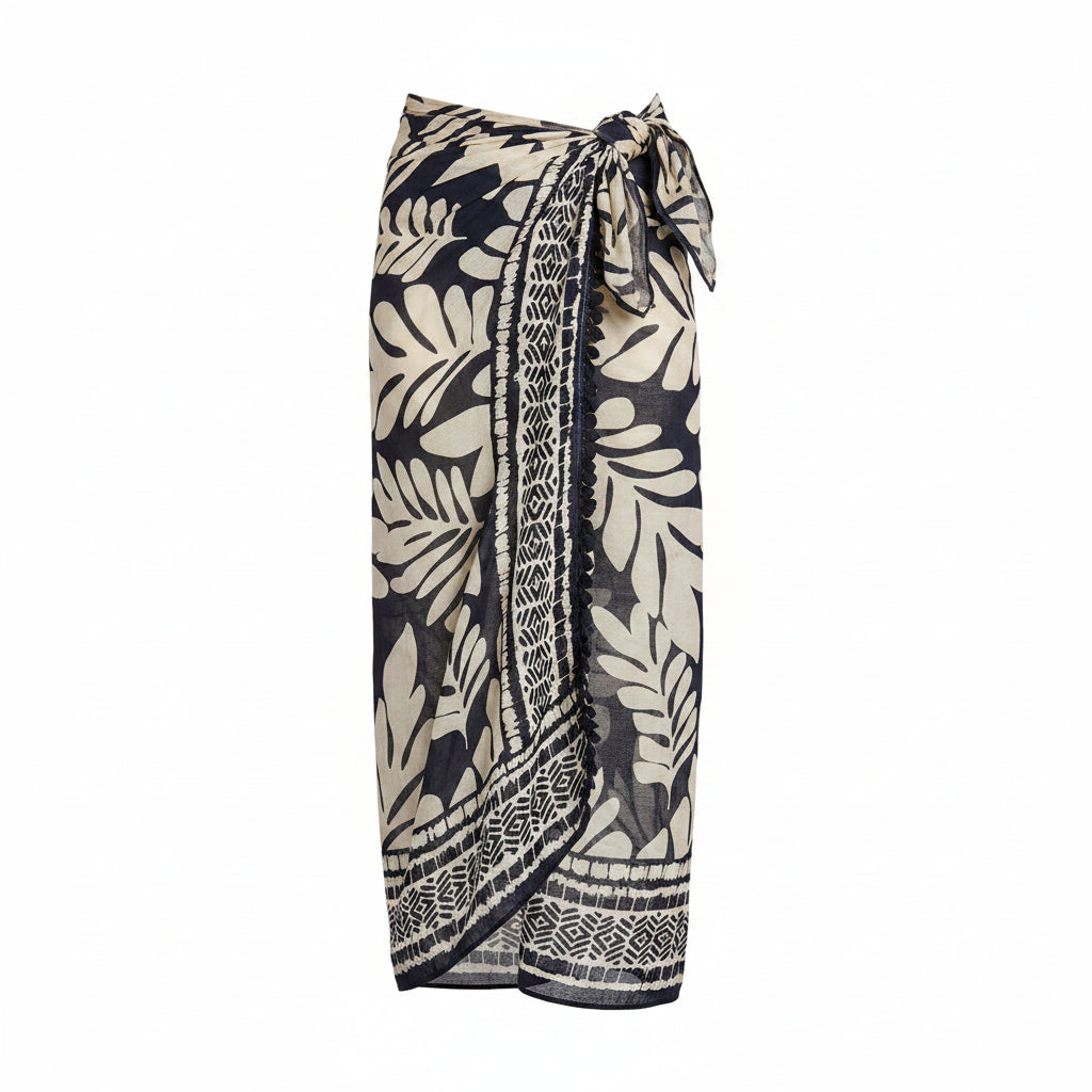 Leaf-pattern pareo in black and beige, tie front, tassel-trim hem; worn over bikini top