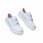 White women's orthopedic sneakers with gold trim, lace eyelets, and gold link ankle strap