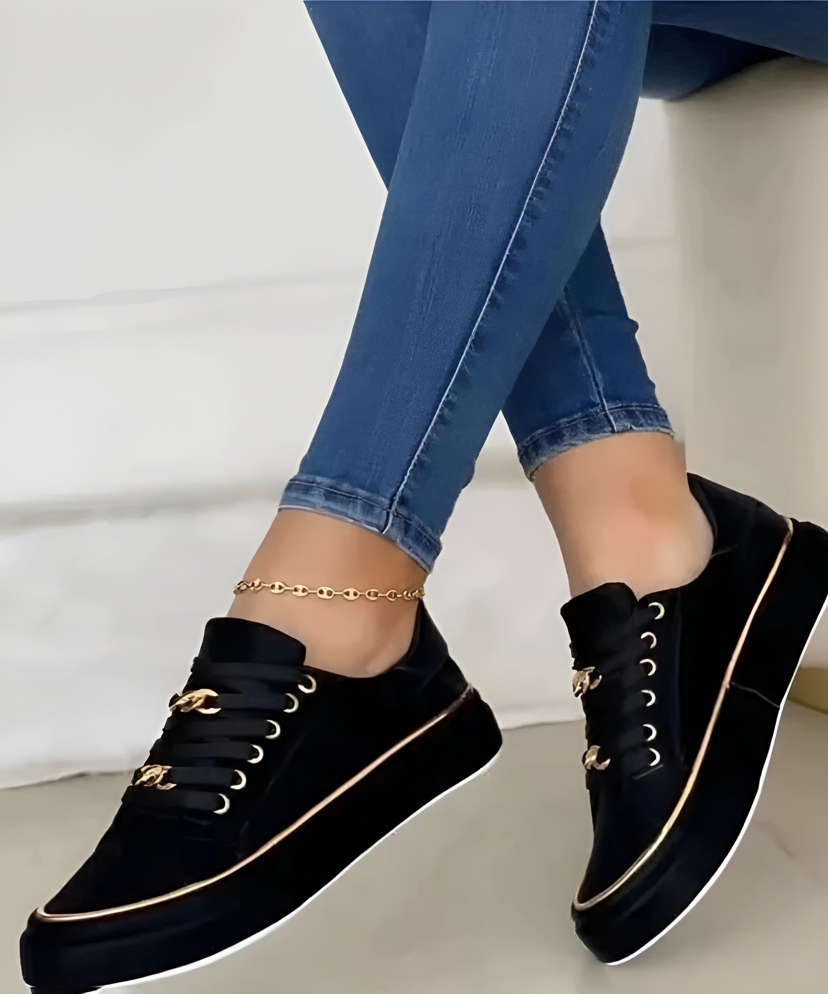 Black women's orthopedic sneakers with gold piping, lace-up front, and gold link ankle strap