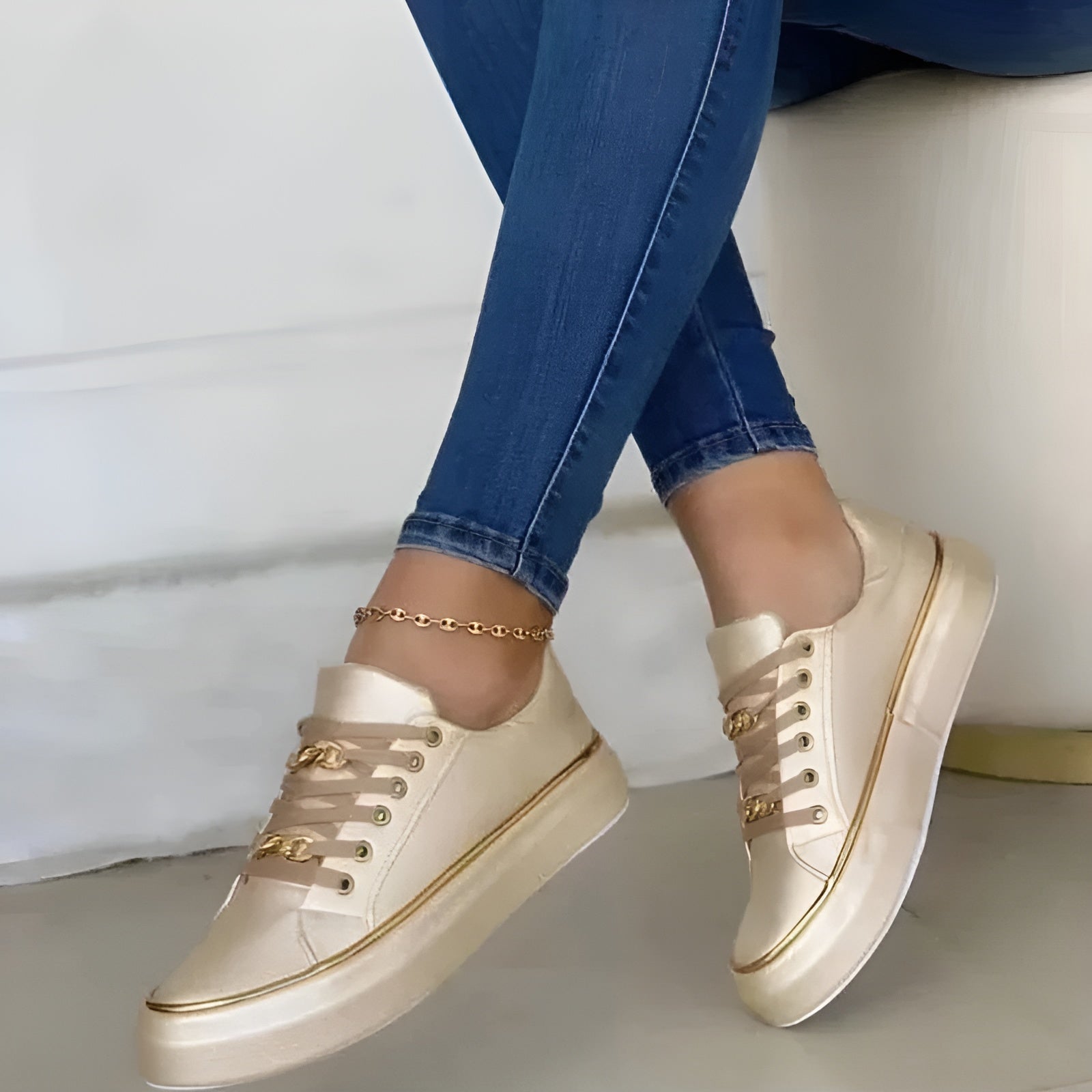 Beige/cream women's orthopedic sneakers with gold trim, lace-up front, and gold link ankle strap