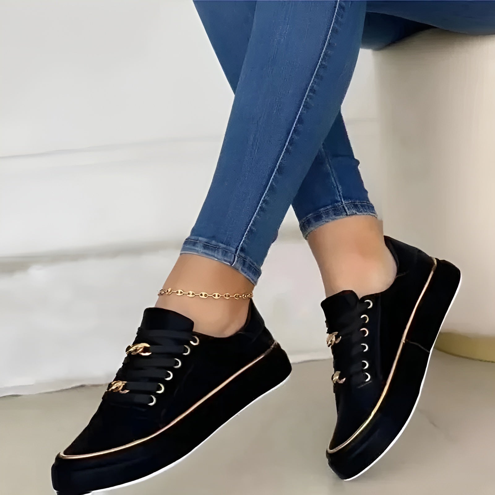 Black women's orthopedic sneakers with gold piping and lace-up front, with gold link ankle strap