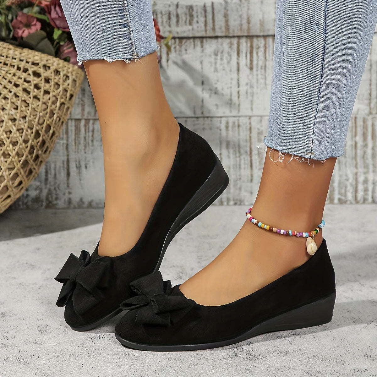 Black bow-front ballerina flats with a low wedge sole