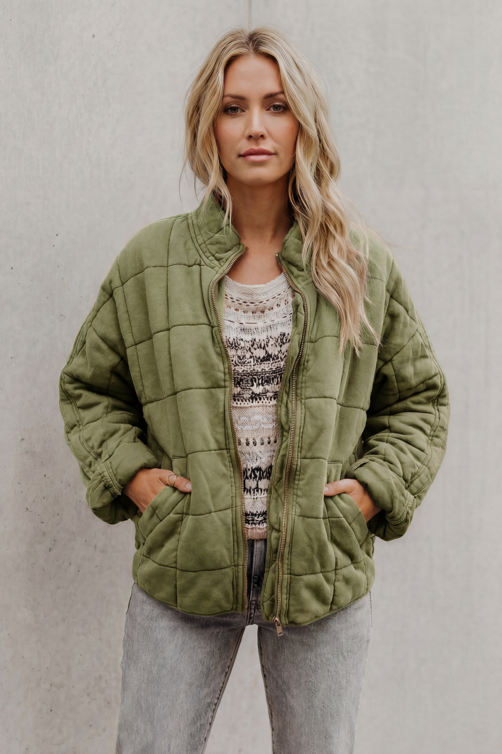 Sage green quilted women’s jacket with front zipper and stand collar.