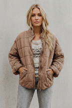 Peach quilted women’s jacket with front zipper and stand collar.