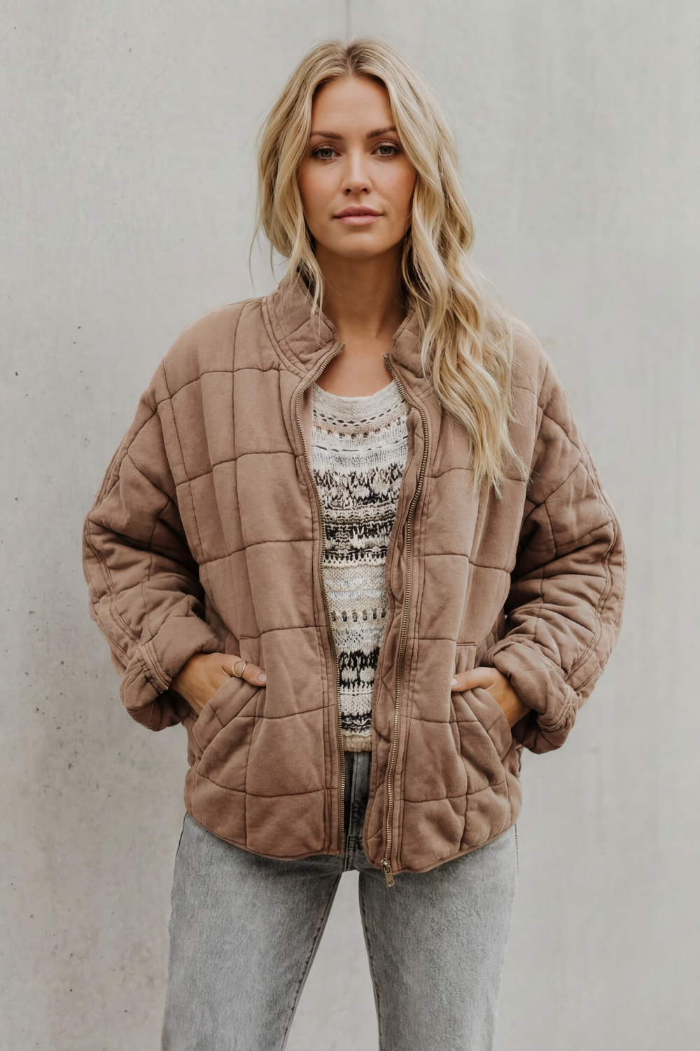 Peach quilted women’s jacket with front zipper and stand collar.