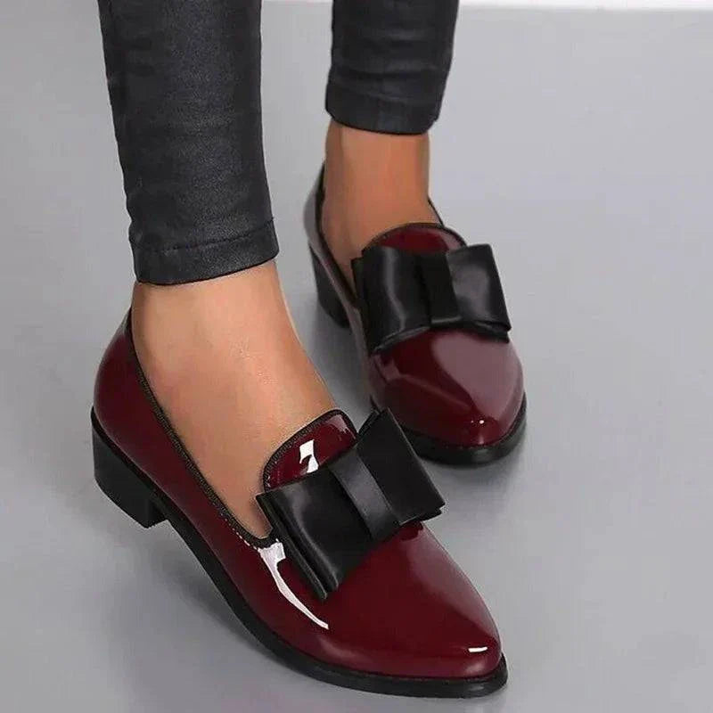 Wine red patent loafers with black bow strap detail and low heel