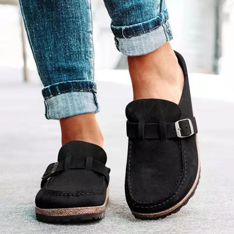 Black slip-on loafers with buckle strap and stitched moc toe