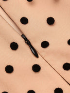 Beige polka-dot fabric with black teardrop zipper detail