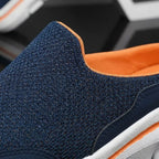 Close-up of navy blue knit indoor slipper upper with orange inner lining