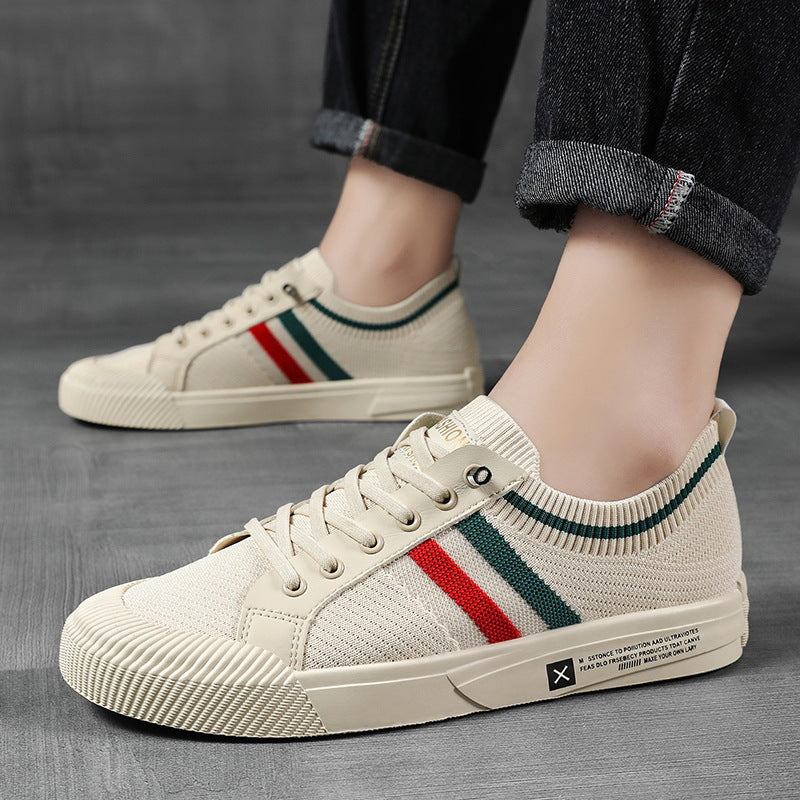 Light sand low-top sneakers with multicolor side stripe, worn with dark jeans