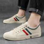 Light sand low-top sneakers with multicolor side stripe, worn with dark jeans