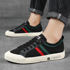 Black low-top sneakers with multicolor side stripe, worn with dark pants