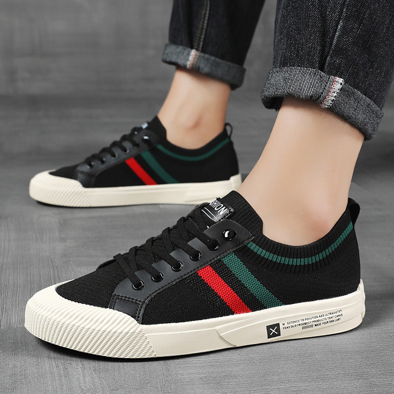 Black low-top sneakers with multicolor side stripe, worn with dark pants