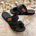 Black women’s comfort slide sandals with toe strap and tan logo patch