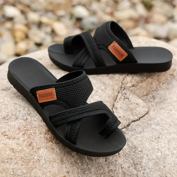 Black women’s comfort slide sandals with toe strap and tan logo patch