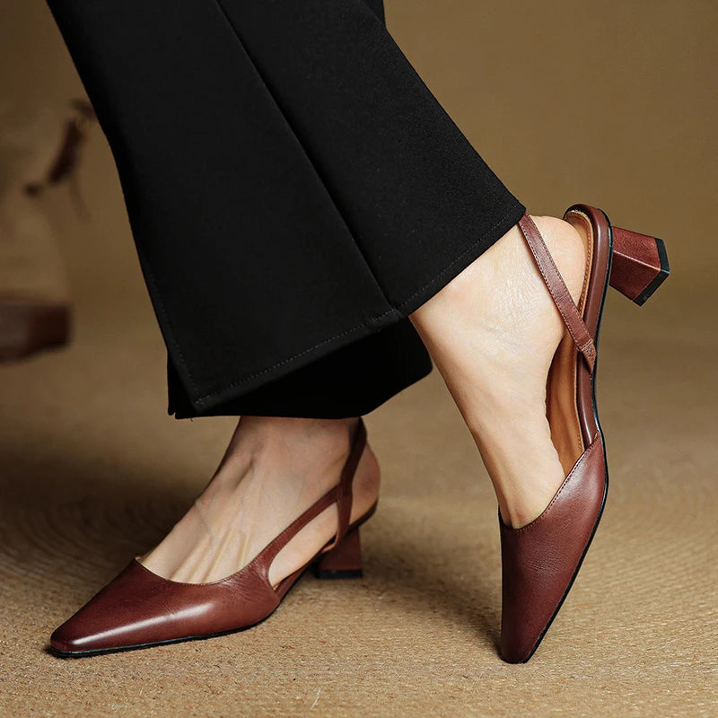 Brown leather pointed-toe slingback heels with low block heel and ankle strap.