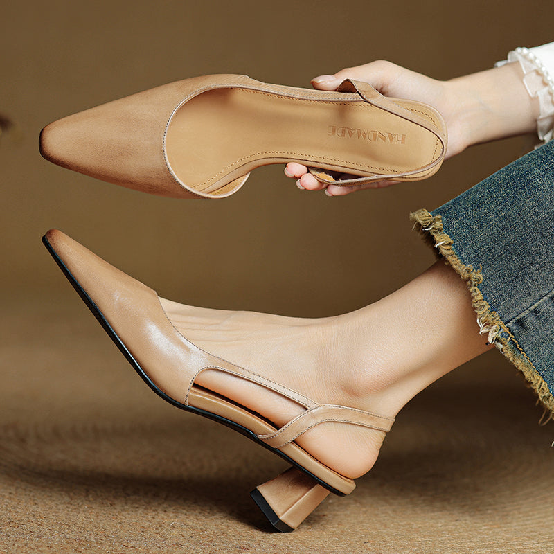 Beige leather slingback heels with pointed toe and low block heel, worn.