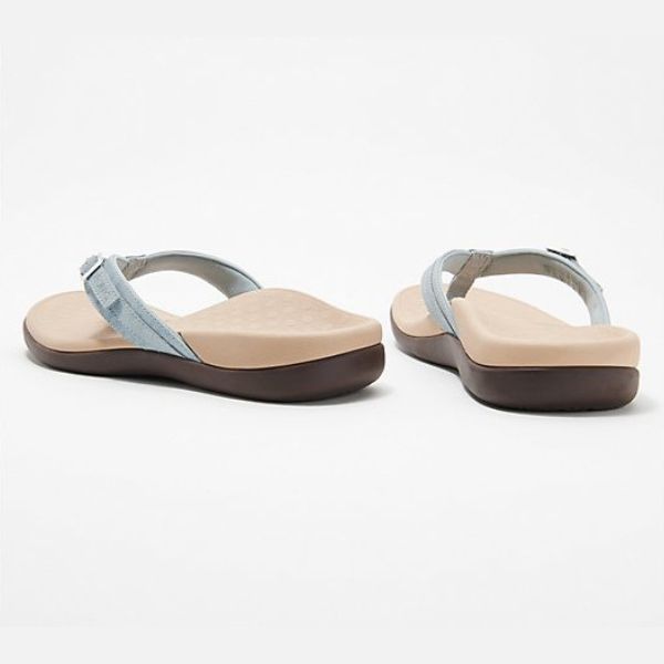 Pair of light blue womens flip-flop sandals with buckle strap and brown sole