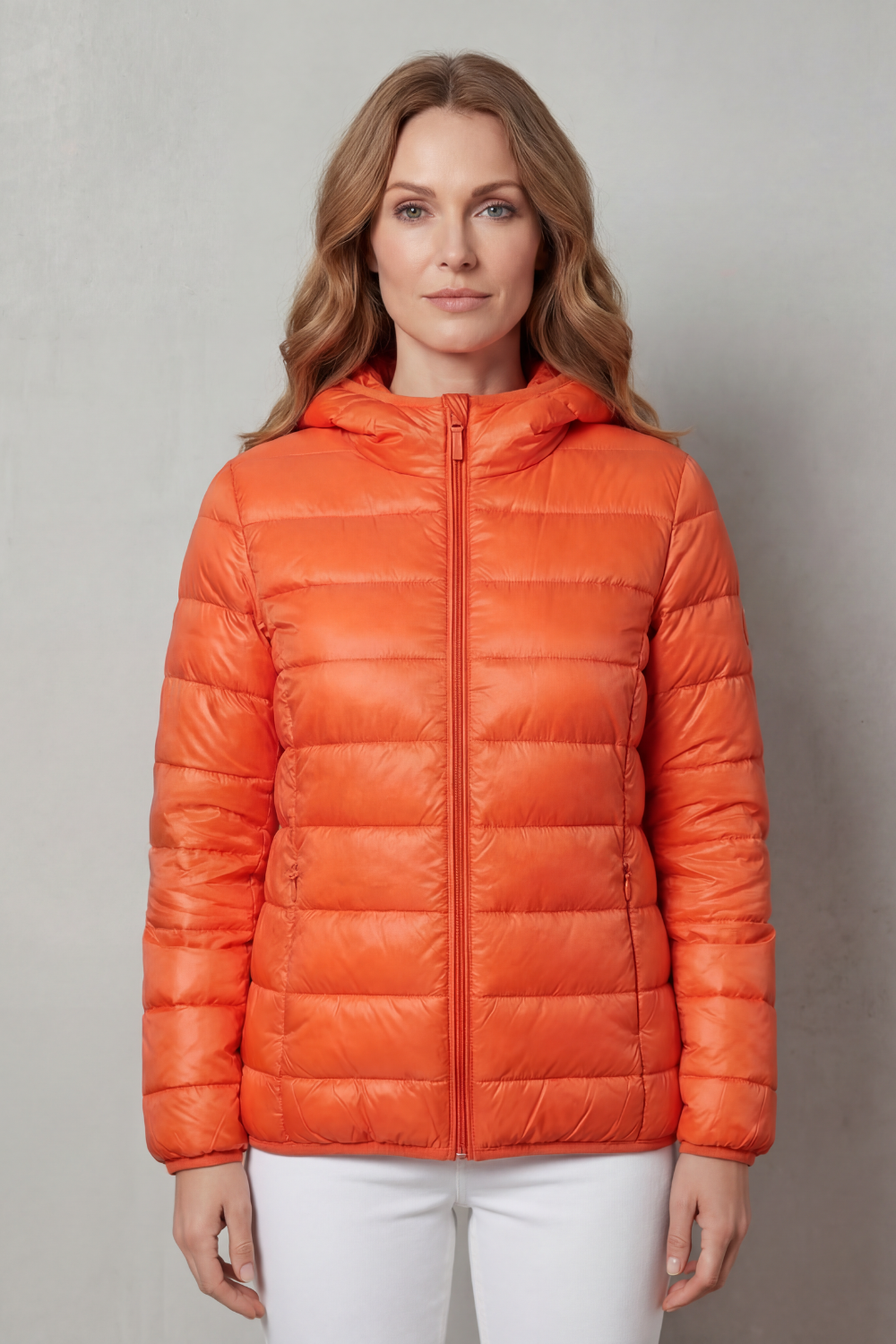 Orange hooded puffer jacket with lightweight quilting and full-zip front