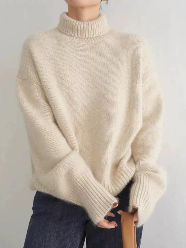 Beige turtleneck knit sweater with ribbed collar, cuffs, and hem.