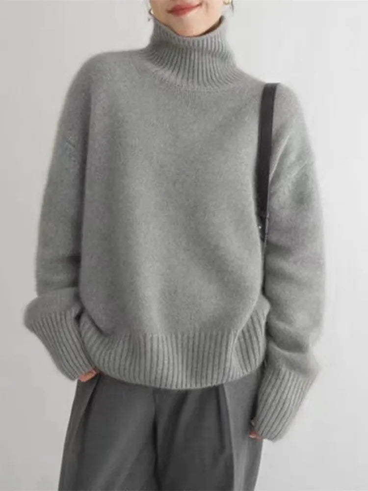 Grey turtleneck knit sweater with long sleeves and ribbed cuffs and hem.