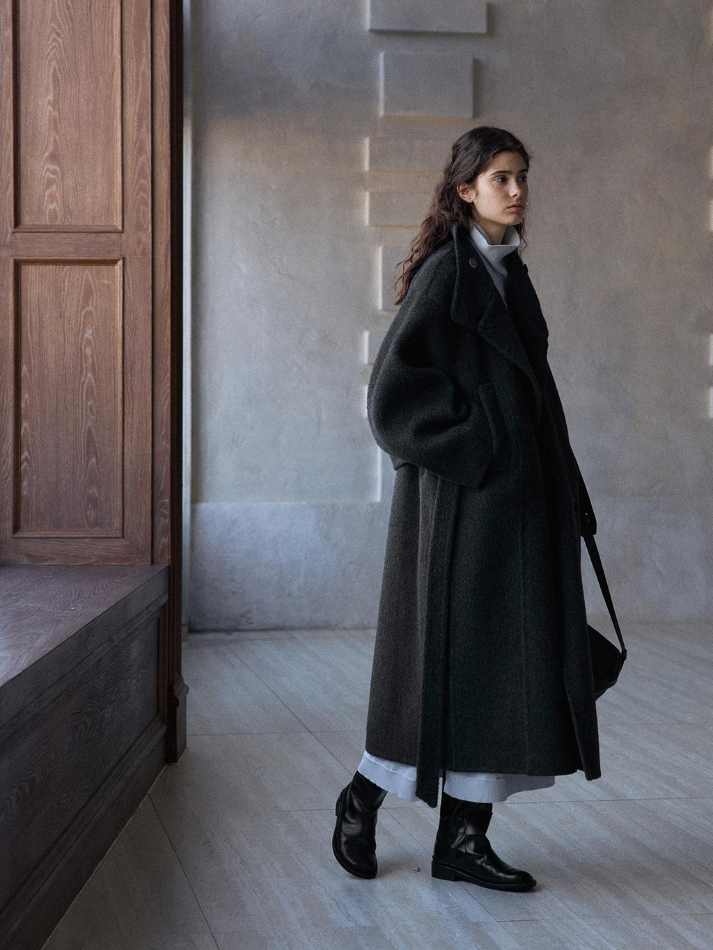 Dark gray long wool belted coat with stand collar, walking stance