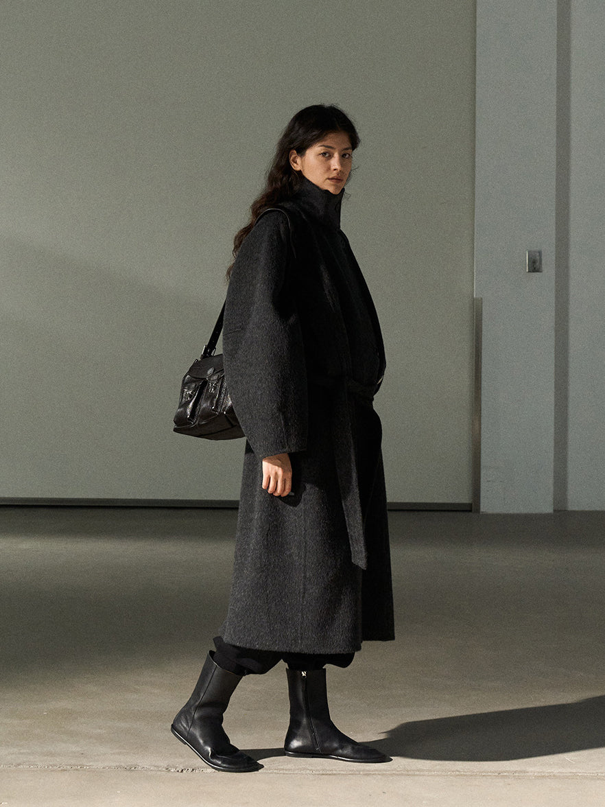 Dark gray wool long belted coat with stand collar, three-quarter side view
