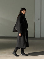 Dark gray wool long belted coat with stand collar, three-quarter side view