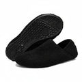Black cozy slip-on barefoot slippers with textured rubber outsole view