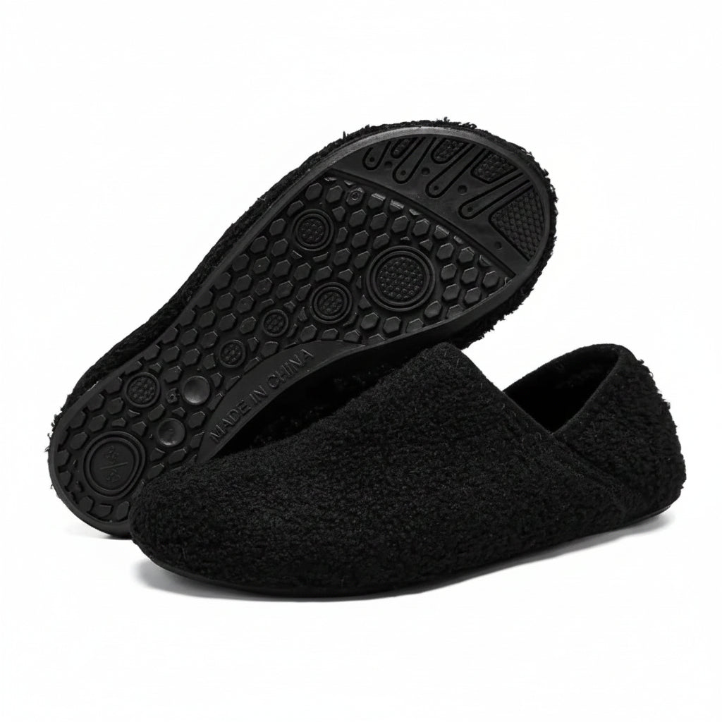 Black cozy slip-on barefoot slippers with textured rubber outsole view
