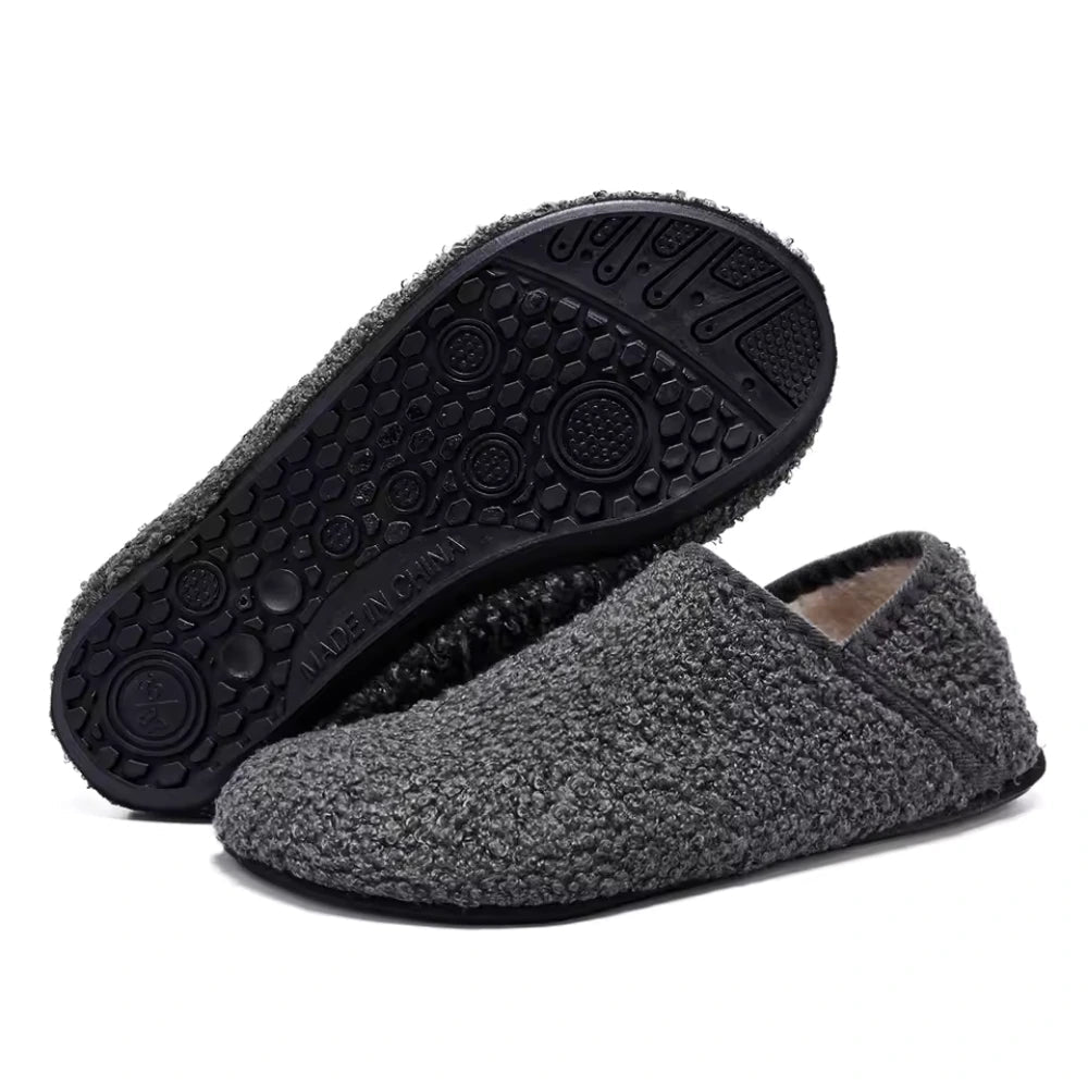 Grey plush slip-on barefoot slippers with black textured rubber outsole view