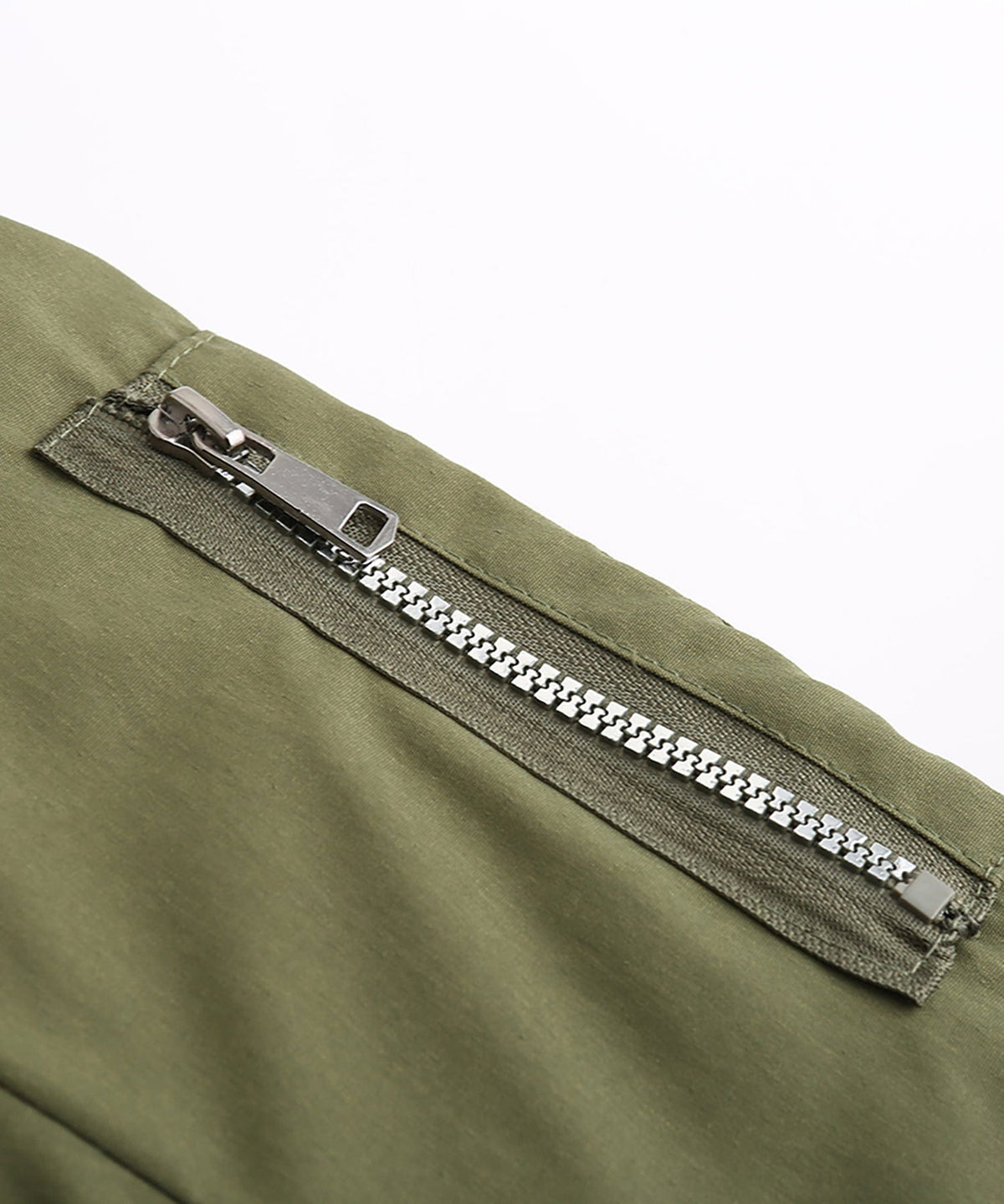 Close-up of olive green parka zipper with silver-toned pull and teeth