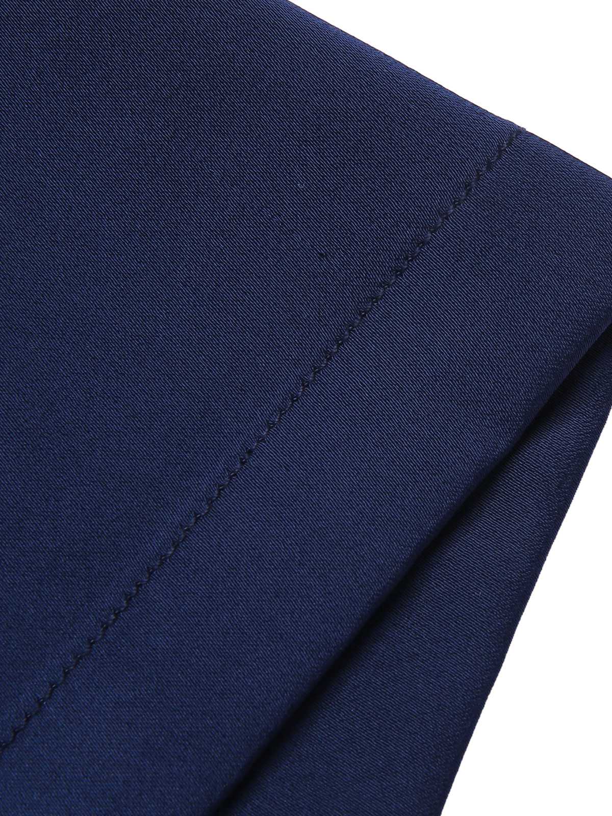 Close-up of dark blue jumpsuit fabric showing stitched seam