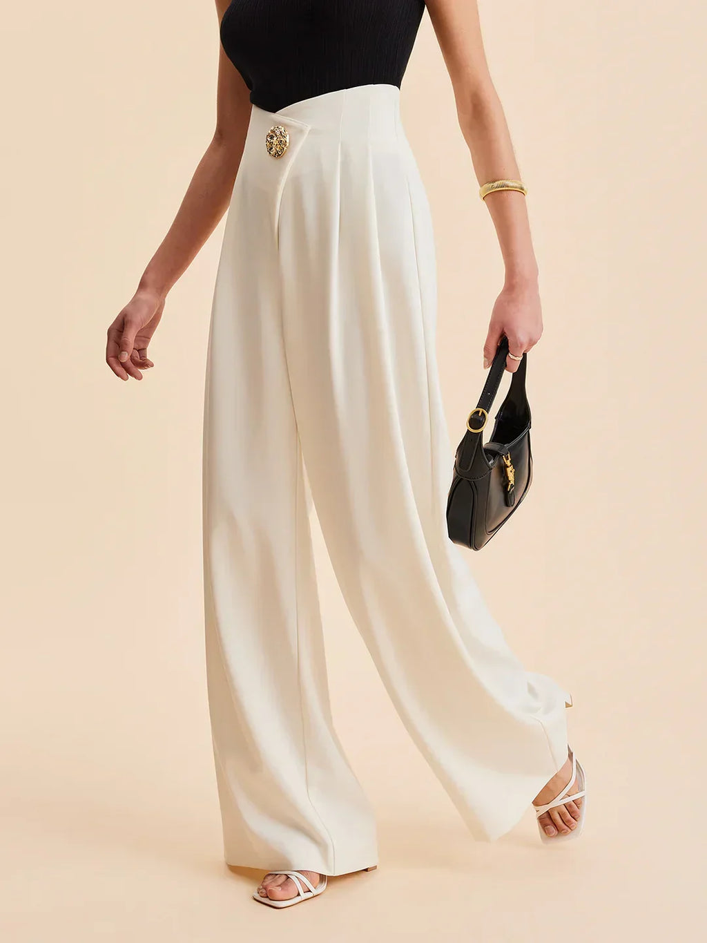 Cream wide-leg tailored pants with gold button at the waistband