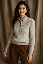 Light gray-white cable-knit sweater with dark buttons and ribbed cuffs