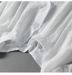 White linen blouse with relaxed fit and buttoned neckline detail