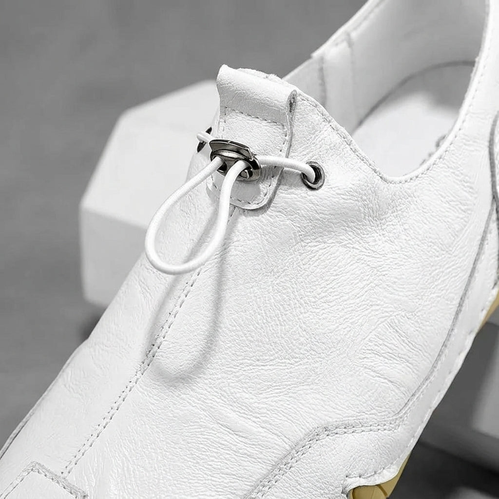White leather casual sneaker with lace-up and metal eyelet loop detail.